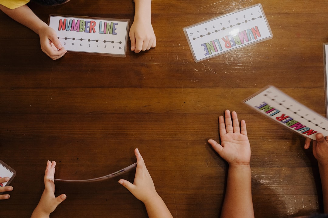 a-group-of-people-sitting-around-a-wooden-table-qvj6xb2-gvu